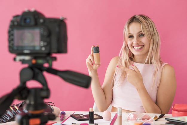 A social media influencer creating video content - promoting makeup