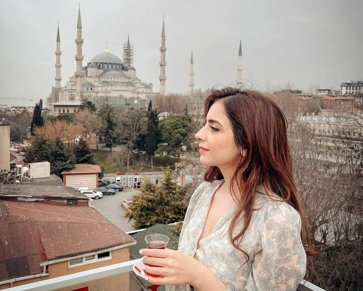 Aliyah Sadegh on a balcony in Istanbul Turkey drinking tea