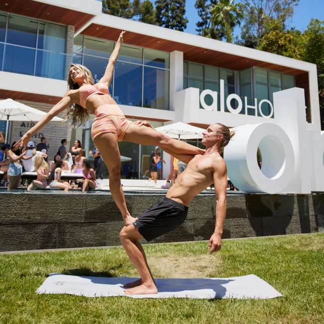 Alo House yoga retreat | Couple doing yoga pose on grass