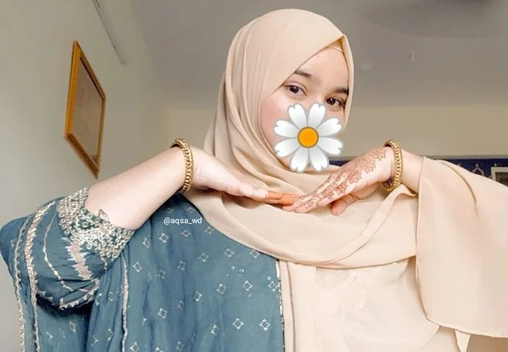 Aqsa Duduke wearing baju kurung and henna design on hand