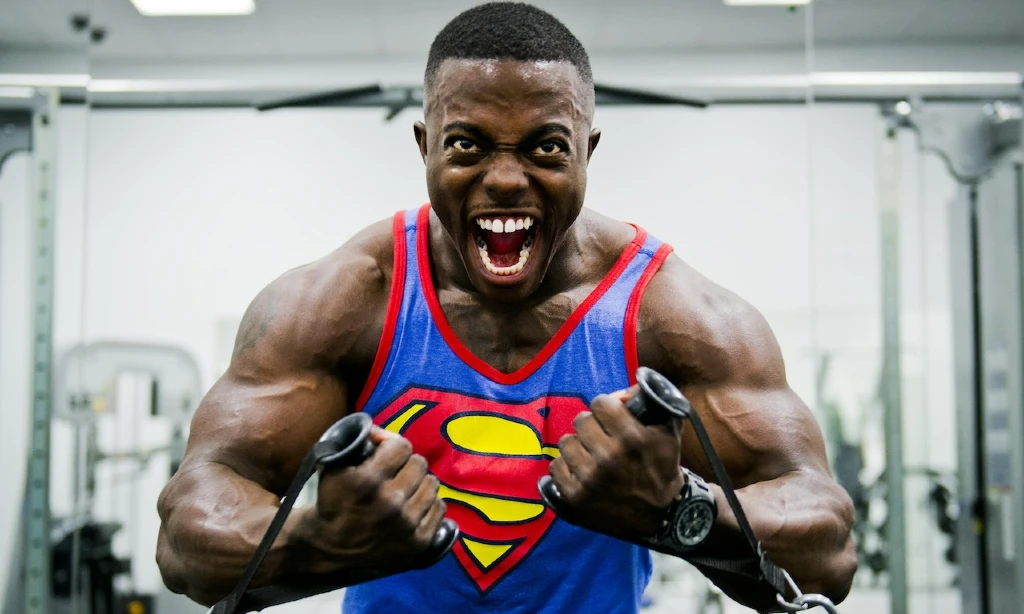 Bodybuilder scream as he works out in the gym | Superman vest