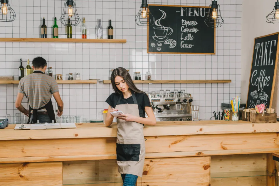 Coffee shop barista at the counter checking a customer order