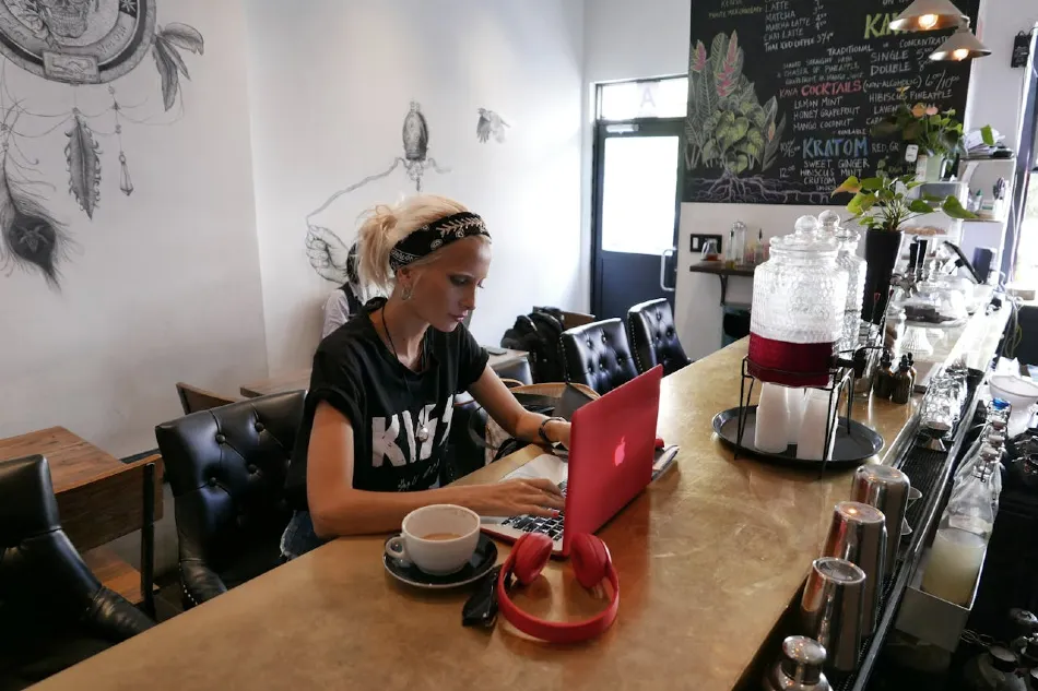 Coffee shop owner on laptop managing accounts