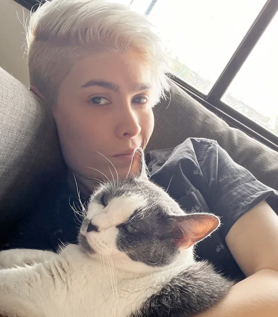 Eli Erlick cuddling her cat on the sofa