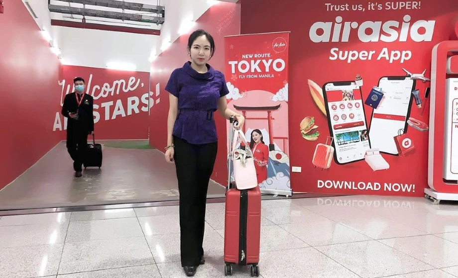Fatima aka Fat Cap with travel suitcase | AirAsia banners