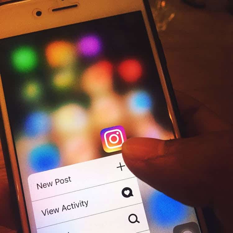 A person touches the Instagram app icon on their iPhone opening the dropdown menu | Influencer Tiers