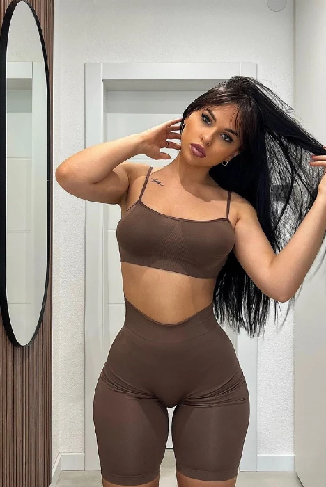 Jana Colovic playing with her hair and wearing brown workout clothing