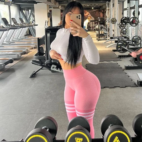 Jana Colovic in pink leggings posing in the gym