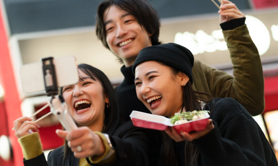 Japanese influencers laughing and eating while making a TikTok video