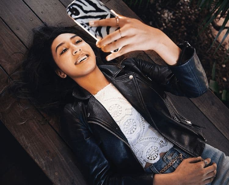 Lumee Influencer lying down on bench while looking at her mobile phone