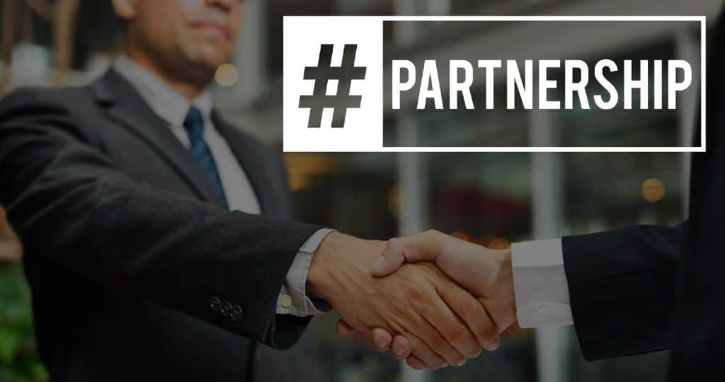 Men in suits shaking hands | Partnership hashtag