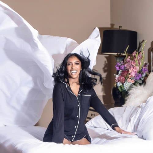Porsha Williams laughing and bouncing on the bed