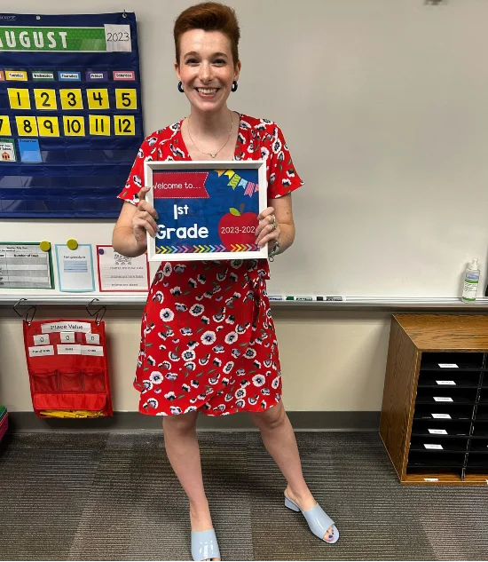Rachel Platt holding up a welcome to 1st grade frame | Education influencers