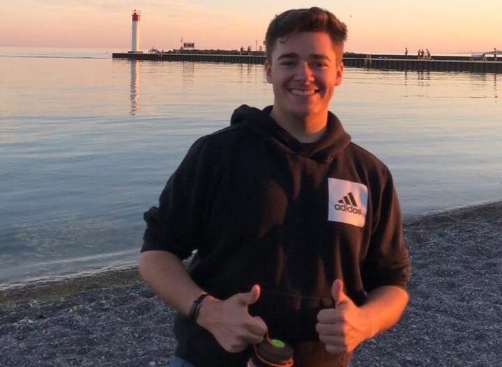Rowan McInnes - Financial Influencer giving thumbs up by the seaside