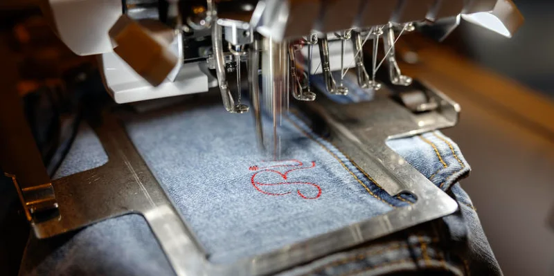 Stitching letters into denim | Sewing machine closeup of needle