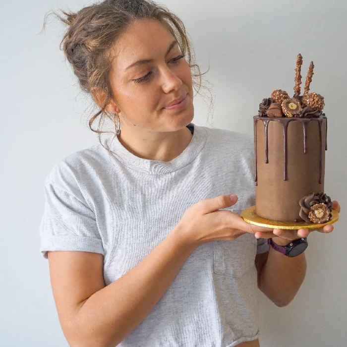 Stephanie Carr holding up a tower chocolate cake