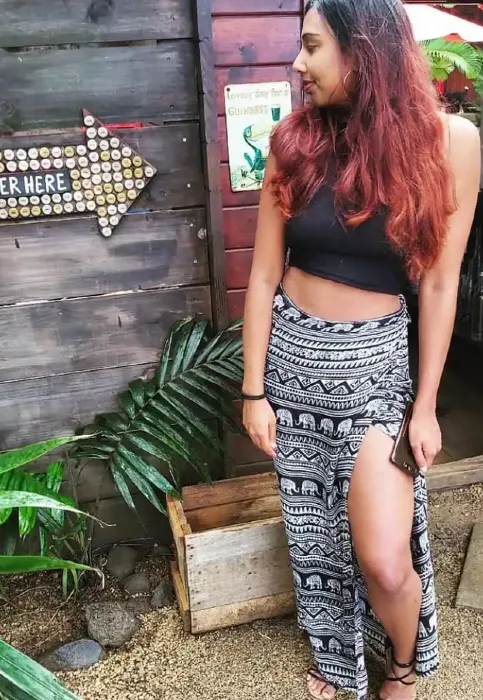 Tarini Ramsewak wearing elephant skirt while posing in front of a beer shed